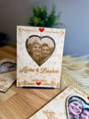 Comparison shot showing both custom wooden heart card styles—one with an engraved photo area, the other with a removable paper photo slot for changing images anytime.